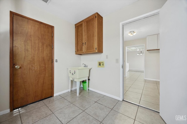 laundry area with hookup for a washing machine, laundry area, light tile patterned flooring, and baseboards