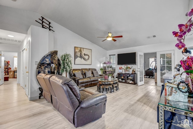 living room with ceiling fan, lofted ceiling, light wood-type flooring, and french doors