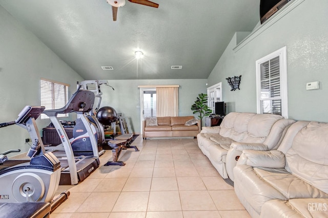 workout area with vaulted ceiling, plenty of natural light, and light tile patterned flooring