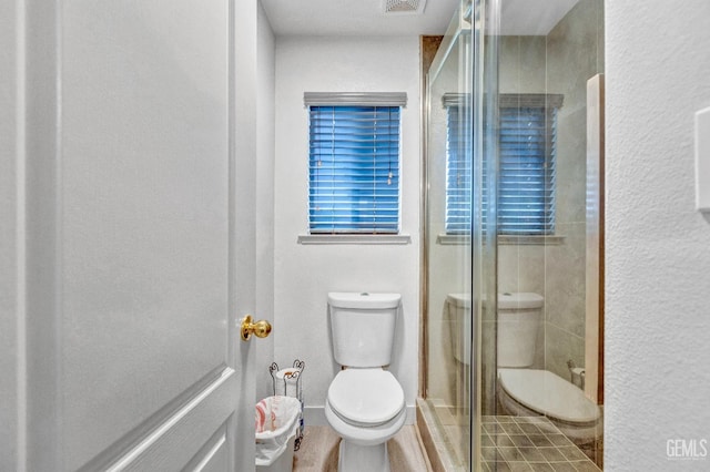 bathroom featuring toilet and walk in shower