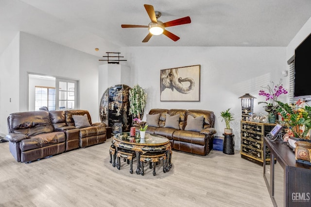 living room featuring lofted ceiling, light hardwood / wood-style flooring, and ceiling fan