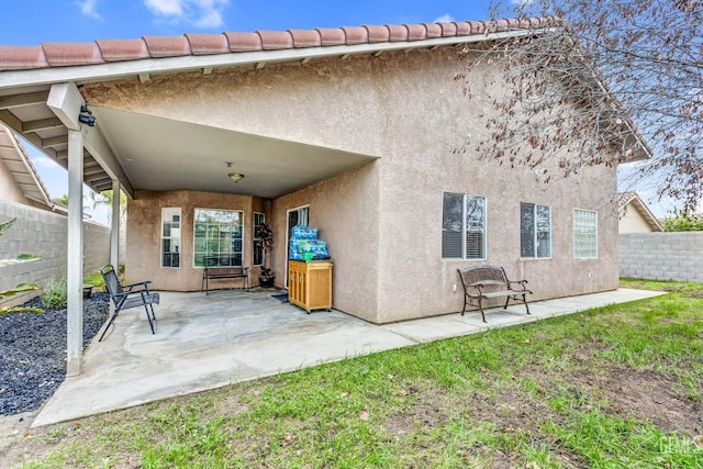 rear view of property featuring a yard and a patio