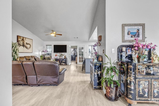 living room featuring vaulted ceiling, light hardwood / wood-style floors, and ceiling fan