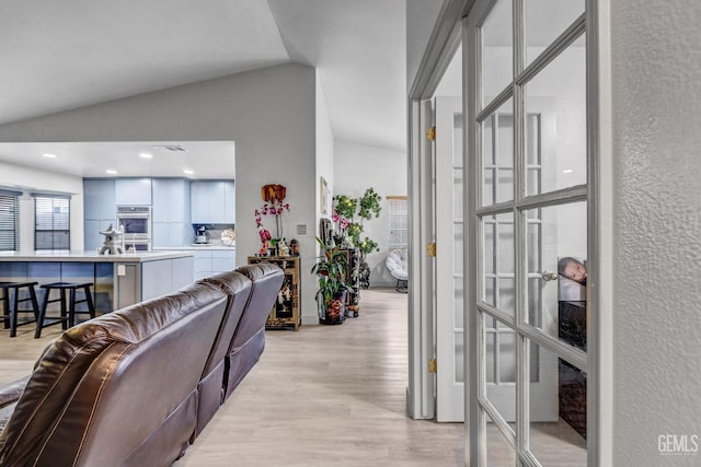 living room with lofted ceiling and light wood-type flooring