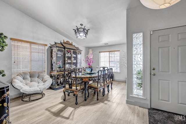 dining space with lofted ceiling and light hardwood / wood-style floors