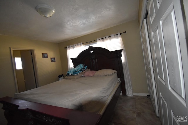 bedroom with multiple windows and dark tile patterned floors