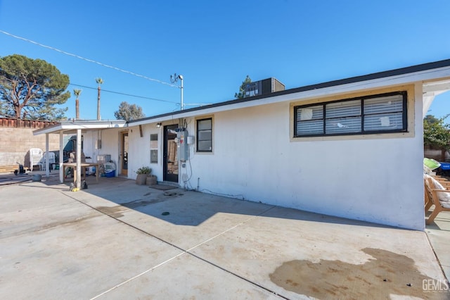 rear view of house featuring fence and a patio