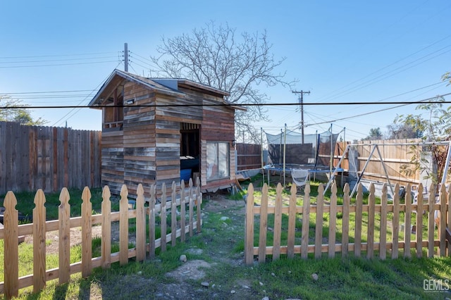 exterior space with a trampoline and a fenced backyard