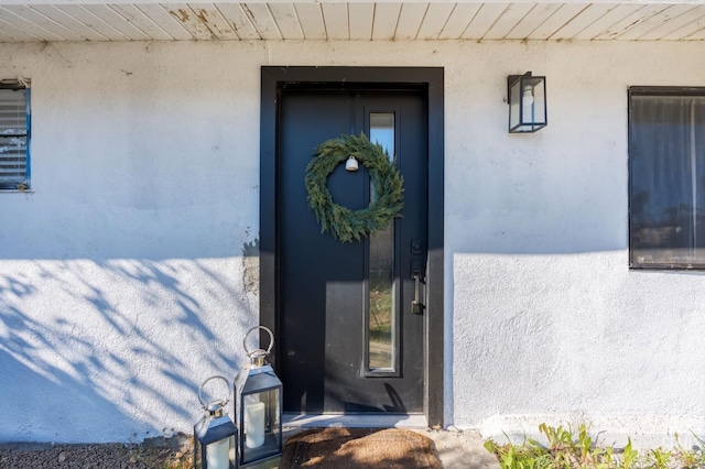 entrance to property with stucco siding