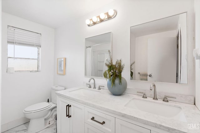 full bathroom featuring toilet, marble finish floor, double vanity, and a sink