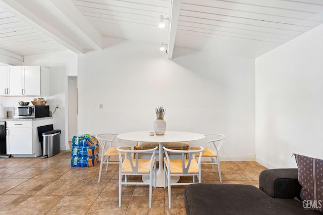 dining space with wooden ceiling, lofted ceiling with beams, and baseboards