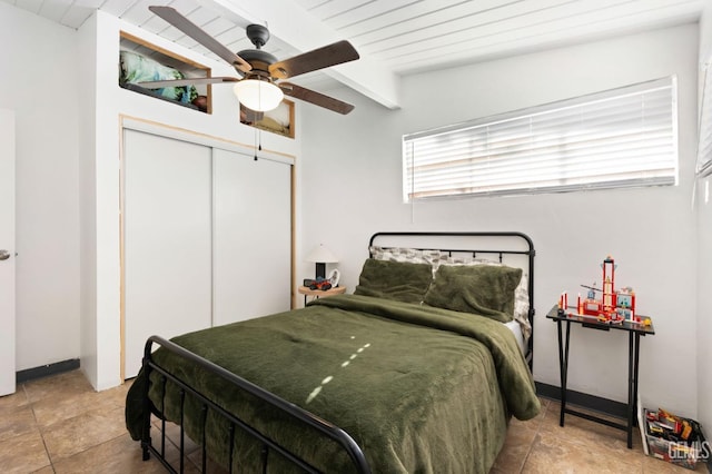 bedroom with a closet, beam ceiling, and a ceiling fan