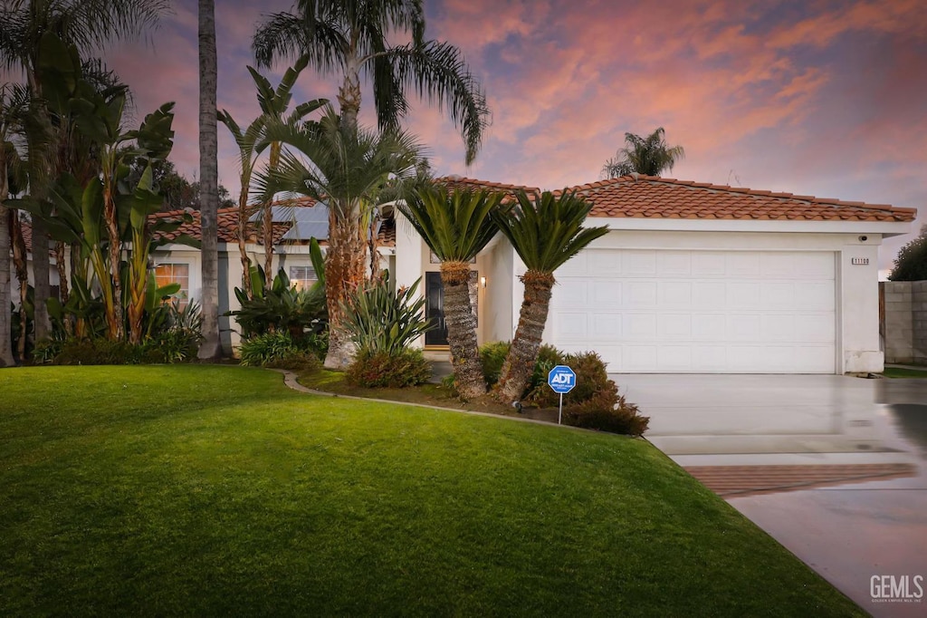 view of front facade with a garage and a lawn