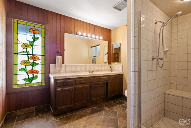 4227 Poso Flat Rd, Bakersfield, CA 93308 - bathroom featuring vanity, wooden walls, stone finish floor, and a stall shower