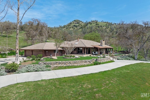 4227 Poso Flat Rd, Bakersfield, CA 93308 - prairie-style home featuring a front lawn, a garage, a chimney, covered porch, and driveway