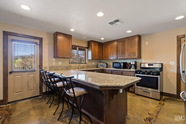 4227 Poso Flat Rd, Bakersfield, CA 93308 - kitchen with stainless steel appliances, visible vents, plenty of natural light, and finished concrete flooring