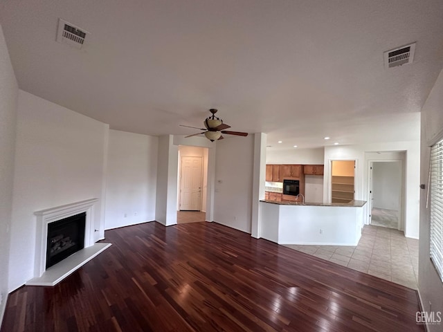 unfurnished living room featuring light hardwood / wood-style floors and ceiling fan