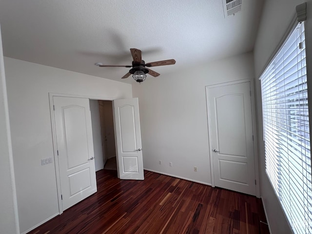 unfurnished bedroom with dark hardwood / wood-style floors and ceiling fan