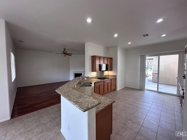 kitchen featuring kitchen peninsula, ceiling fan, sink, and light tile patterned floors