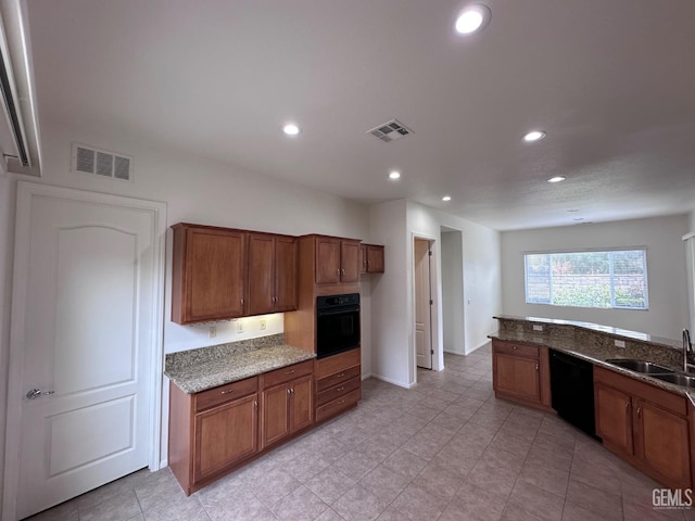 kitchen with sink, dark stone countertops, and black appliances