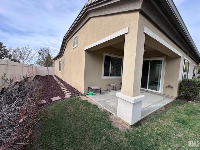 rear view of property with a patio and a lawn