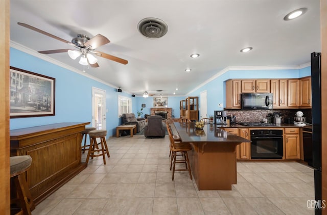 3717 Basin Ave, Bakersfield, CA 93309 - kitchen with black appliances, a fireplace, dark countertops, ceiling fan, and a breakfast bar