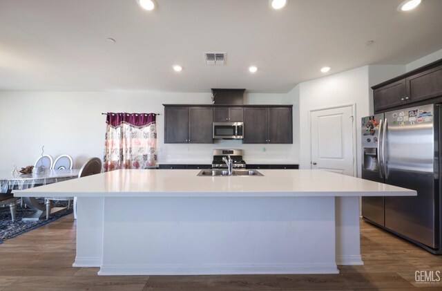 10213 Breitenbush Ave, Bakersfield, CA 93311 - kitchen featuring stainless steel appliances, a center island with sink, dark brown cabinetry, a sink, and light countertops