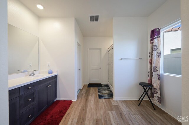 10213 Breitenbush Ave, Bakersfield, CA 93311 - bathroom featuring wood finished floors, vanity, a shower with shower curtain, and baseboards