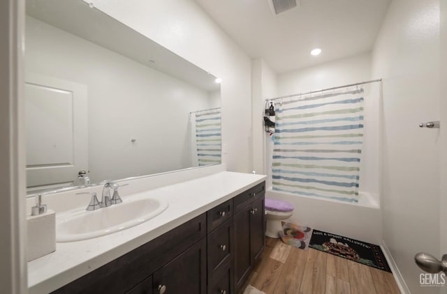 10213 Breitenbush Ave, Bakersfield, CA 93311 - bathroom featuring wood finished floors, vanity, toilet, shower / tub combo with curtain, and recessed lighting