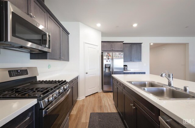 10213 Breitenbush Ave, Bakersfield, CA 93311 - kitchen with stainless steel appliances, a sink, light wood-style floors, light countertops, and dark brown cabinetry