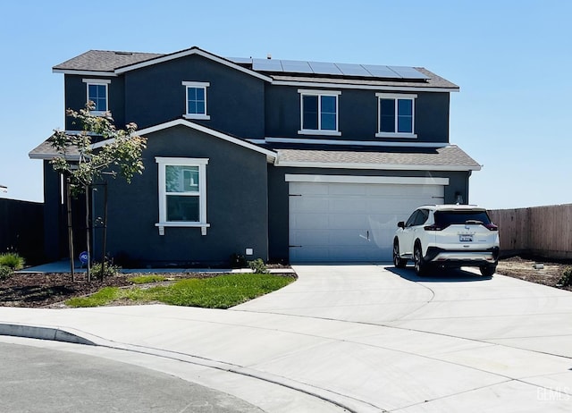 view of property featuring solar panels and a garage