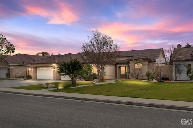 view of front of property with a garage and a yard