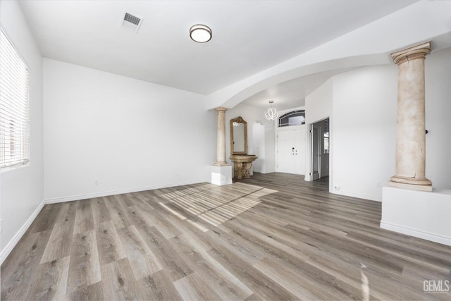 unfurnished living room featuring hardwood / wood-style floors and ornate columns