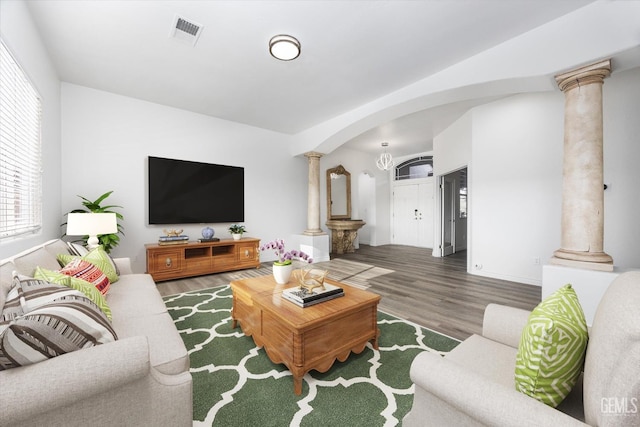 living room featuring decorative columns and dark hardwood / wood-style floors