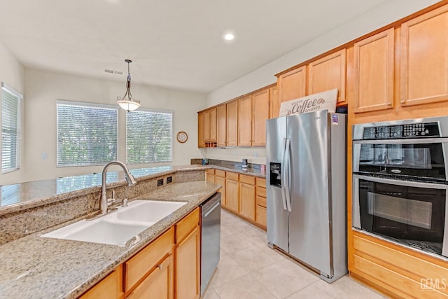 kitchen with a sink, appliances with stainless steel finishes, plenty of natural light, and light tile patterned floors