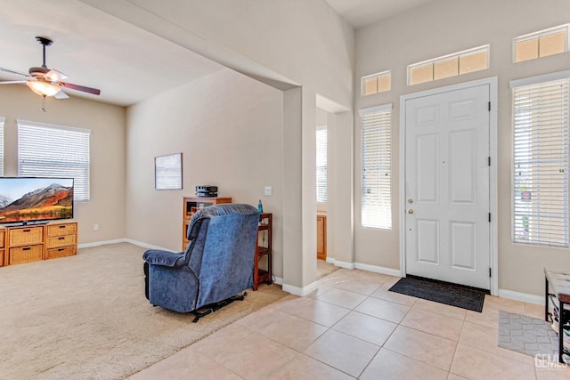 foyer featuring baseboards, ceiling fan, and light tile patterned floors