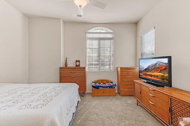 bedroom with ceiling fan, light colored carpet, and visible vents