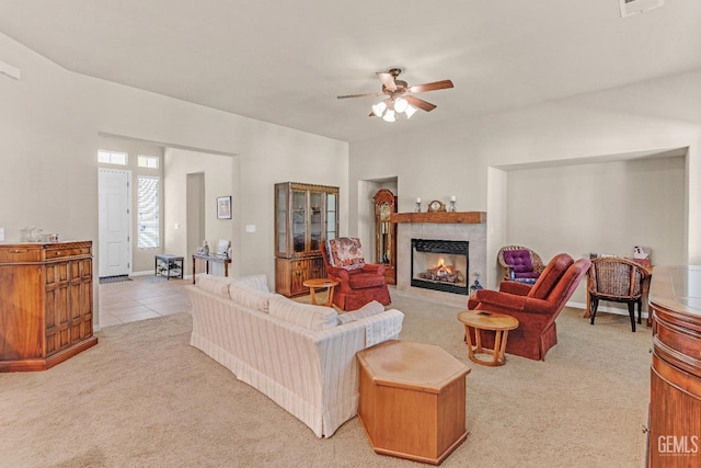 living room with ceiling fan, light carpet, baseboards, light tile patterned floors, and a tile fireplace