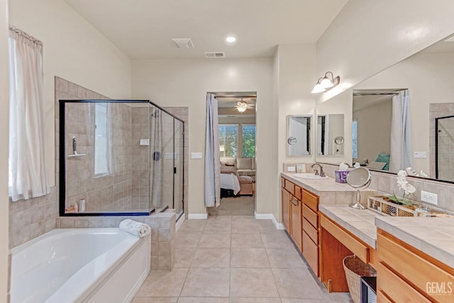 full bath with tile patterned flooring, a ceiling fan, a stall shower, and vanity