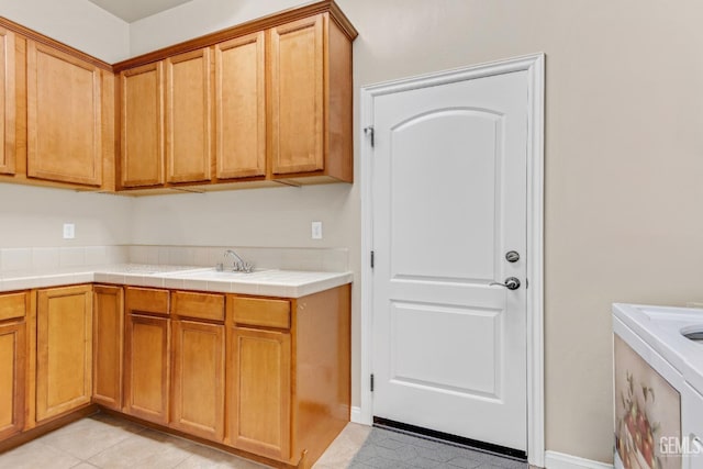 kitchen featuring light tile patterned flooring, tile countertops, and a sink
