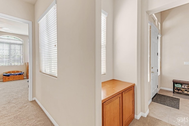 entrance foyer with baseboards and light carpet