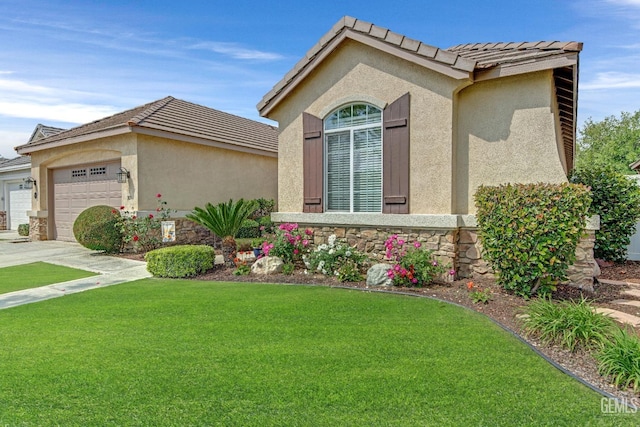 view of front of home featuring a garage, stucco siding, a tile roof, and a front yard