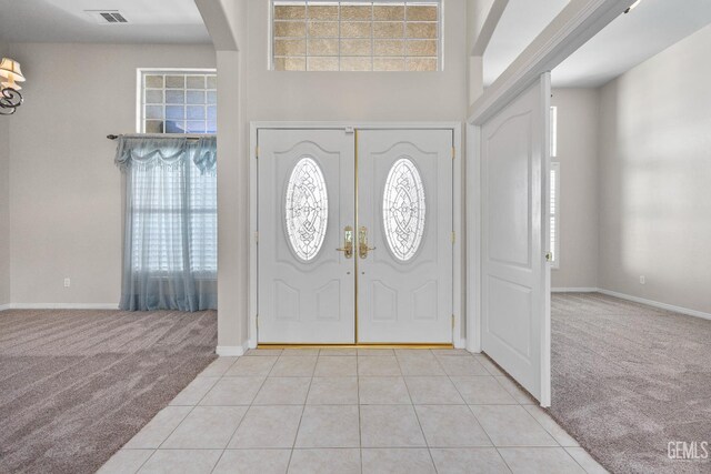 10611 Fishers Peak Dr, Bakersfield, CA 93312 - foyer entrance featuring light carpet, arched walkways, light tile patterned floors, and a high ceiling
