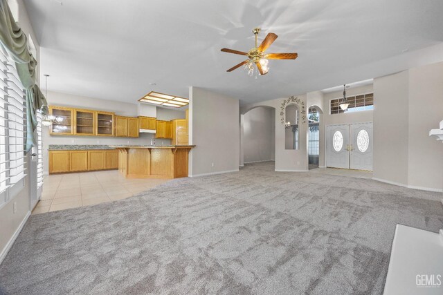 10611 Fishers Peak Dr, Bakersfield, CA 93312 - unfurnished living room featuring arched walkways, light colored carpet, a ceiling fan, and light tile patterned floors