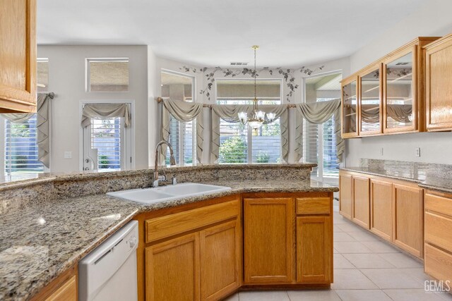 10611 Fishers Peak Dr, Bakersfield, CA 93312 - kitchen with dishwasher, light stone counters, light tile patterned flooring, and glass insert cabinets