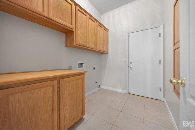 10611 Fishers Peak Dr, Bakersfield, CA 93312 - laundry area with hookup for an electric dryer, hookup for a gas dryer, hookup for a washing machine, light tile patterned floors, and cabinet space