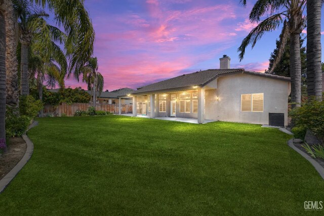 10611 Fishers Peak Dr, Bakersfield, CA 93312 - back of house with stucco siding, a chimney, a tiled roof, and a patio area