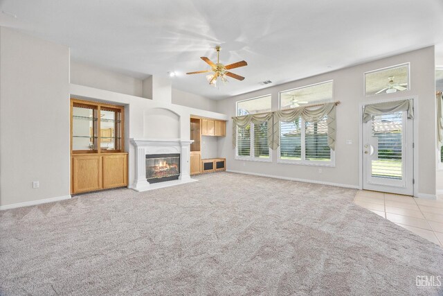 10611 Fishers Peak Dr, Bakersfield, CA 93312 - unfurnished living room featuring a ceiling fan, light carpet, a high end fireplace, and light tile patterned floors