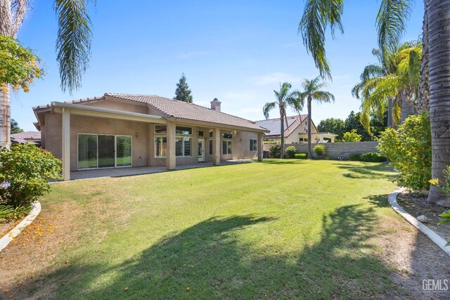 10611 Fishers Peak Dr, Bakersfield, CA 93312 - rear view of house featuring stucco siding, a tiled roof, a chimney, and a patio area