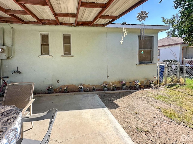 view of home's exterior with a patio, fence, and stucco siding